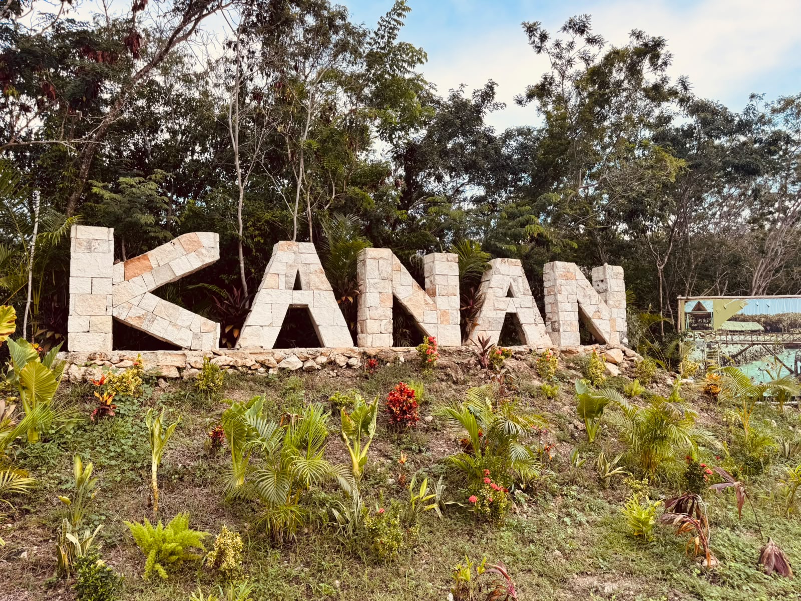 Letrero de piedra KANÁN a la entrada del parque en Cozumel
